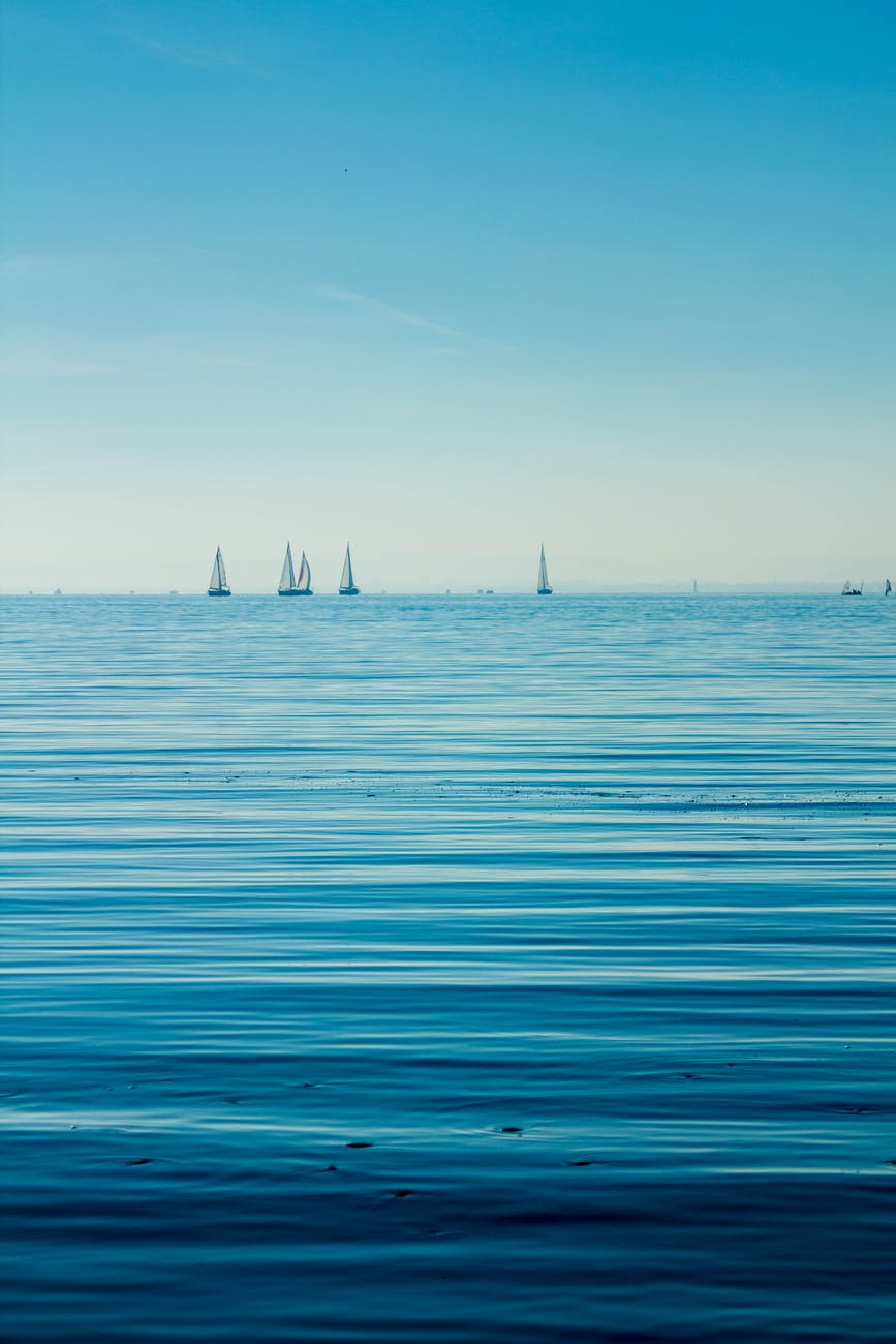 boats on body of water under blue sky