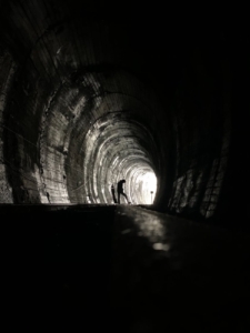 grayscale photo of tunnel with light