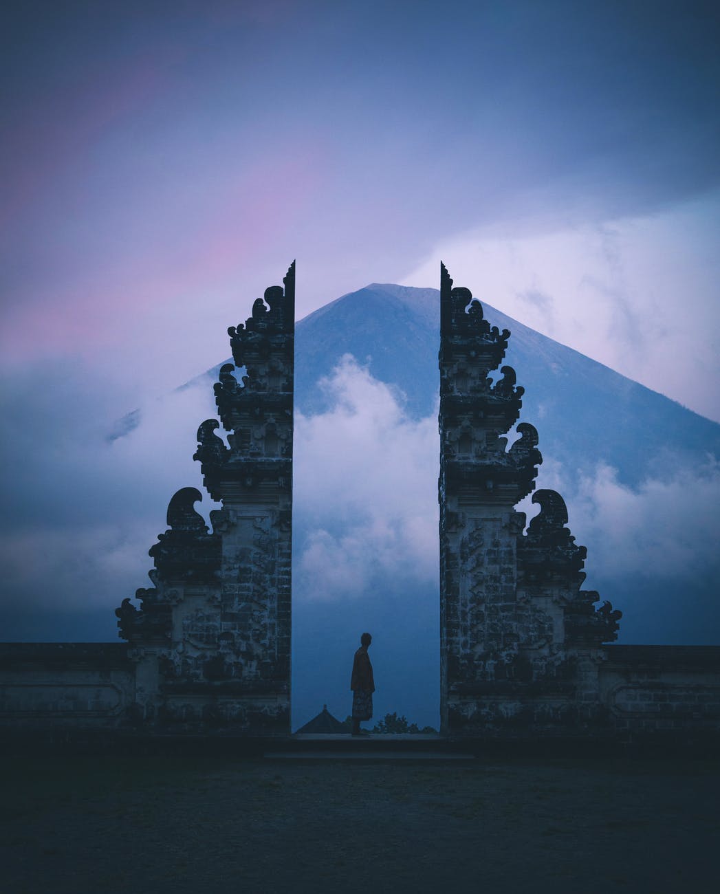 person standing between concrete building