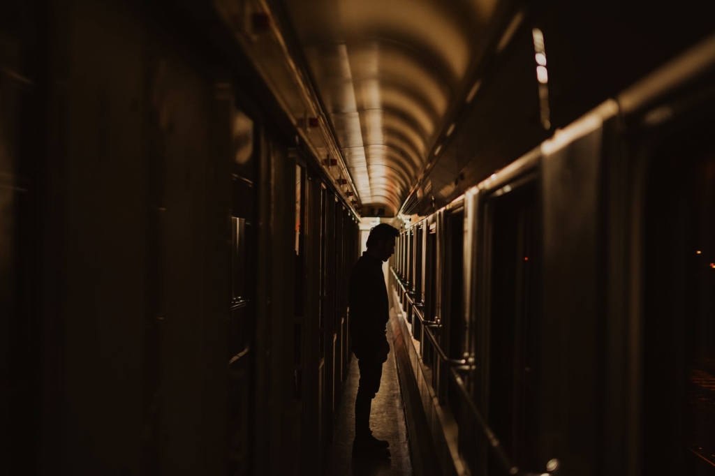 silhouette of man standing in train