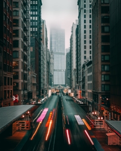 cars on road between high rise buildings