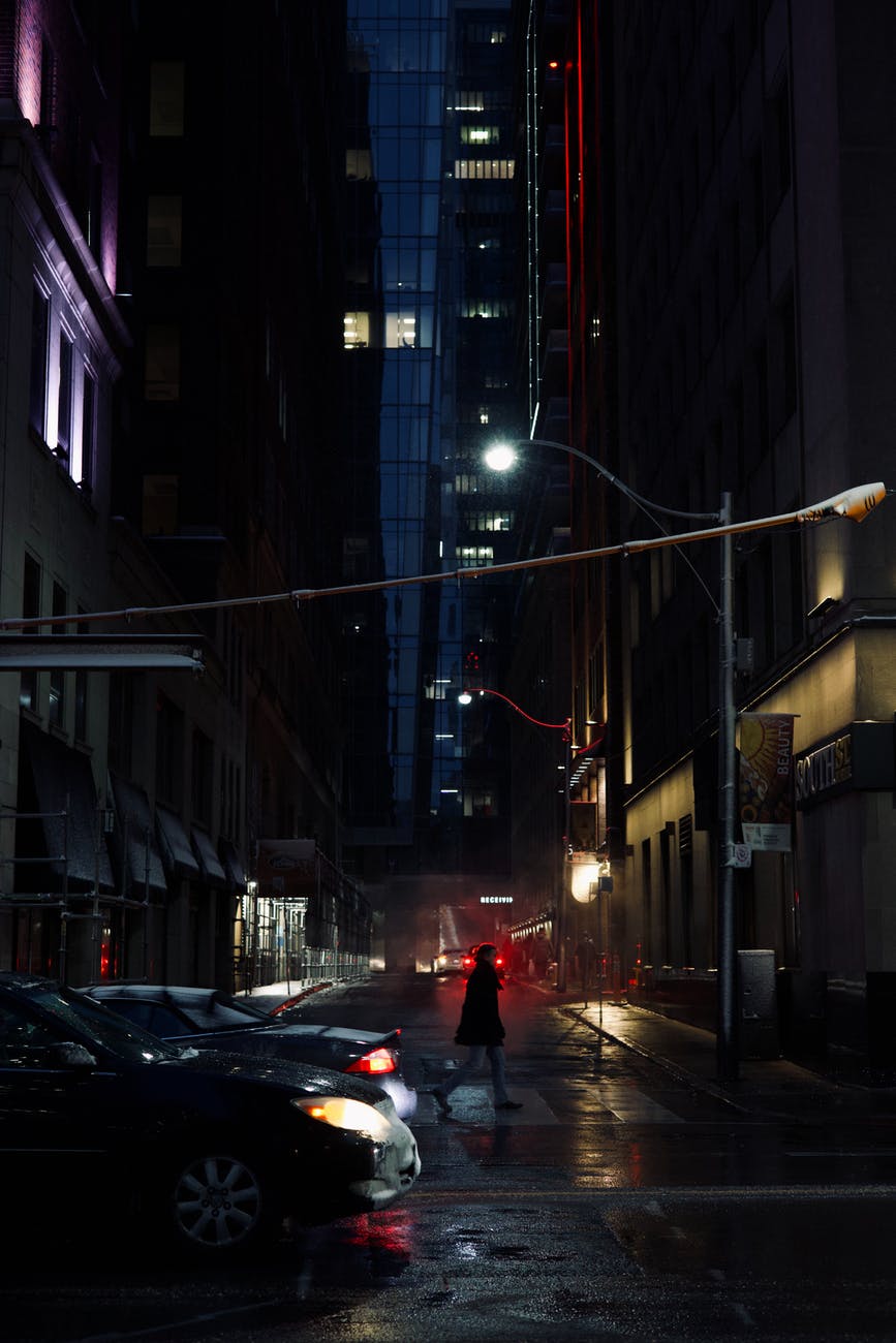 a person in red jacket walking on street during night