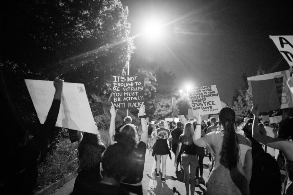 group of people protesting on street at night