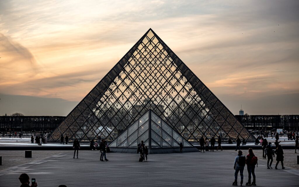 people walking in front of louvre museum