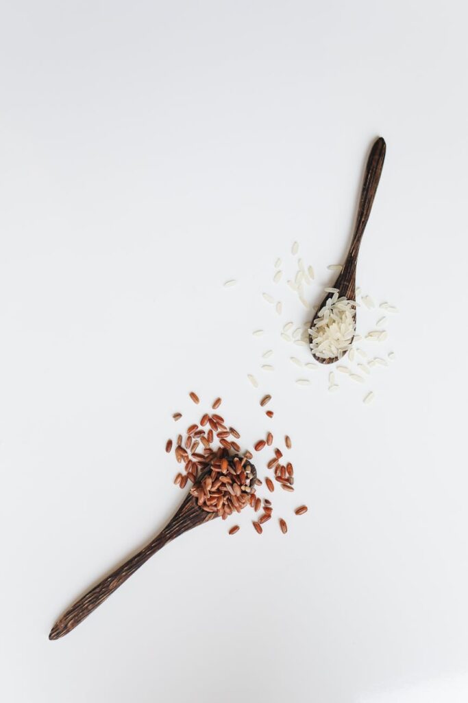 photo of assorted rice grain on wooden spoon